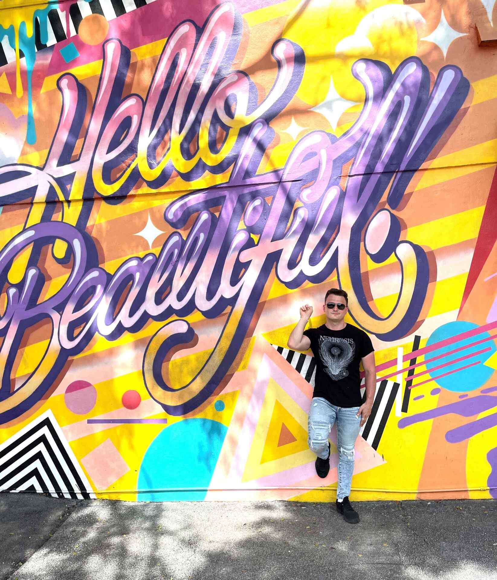Man posing in front of painted wall