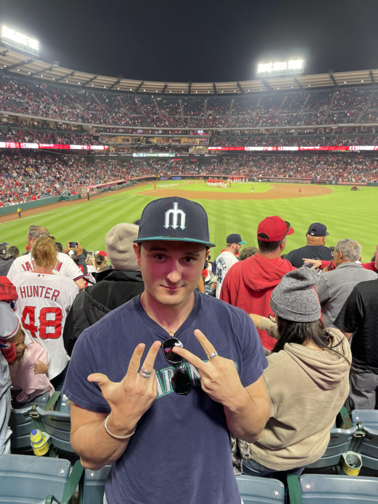 Henry Forest wearing a cap and posing at a stadium