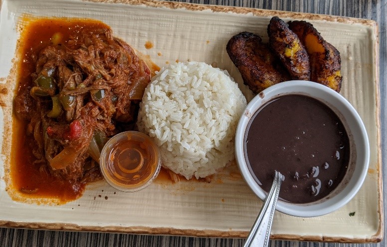 A dish with rice, bananas, and a soup