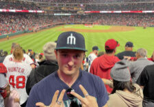 Henry Forest wearing a cap and posing at a stadium